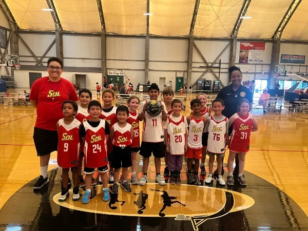 A Little Hoopers team with their coaches at Sol City Sports Center